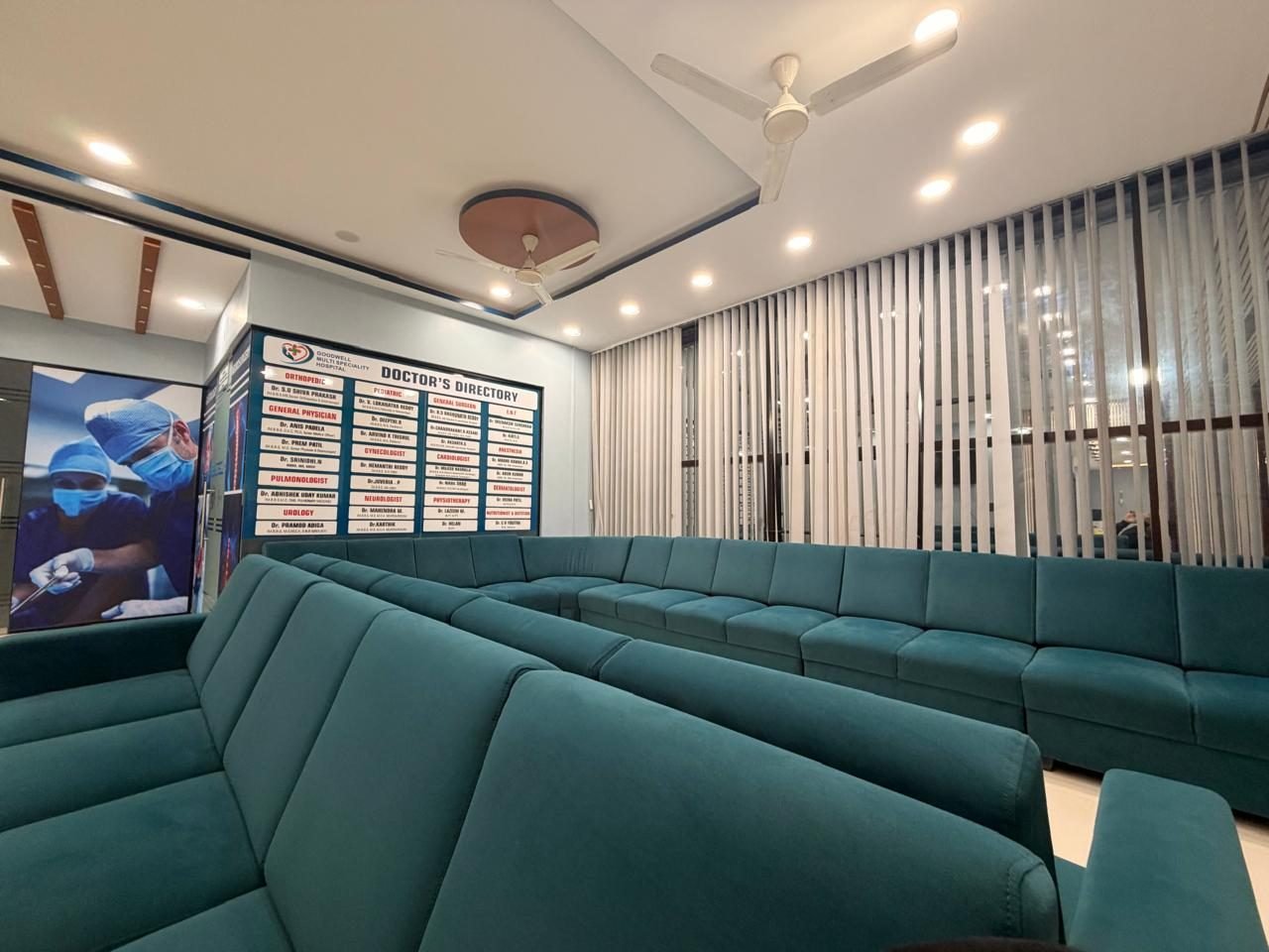 Patient waiting lounge with teal sofas and the doctors directory board